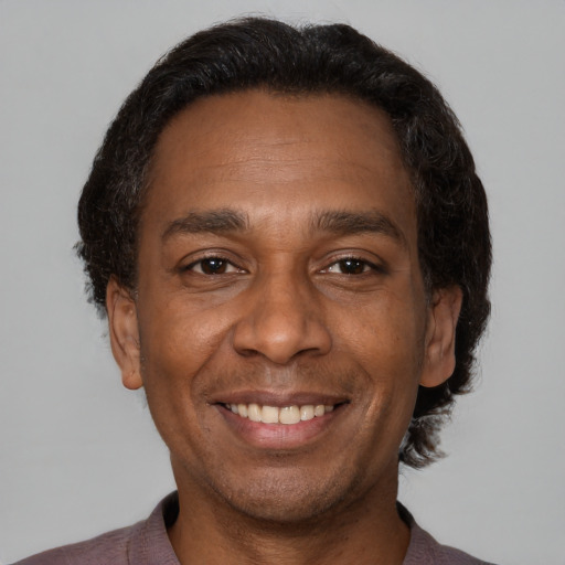Joyful black adult male with short  brown hair and brown eyes