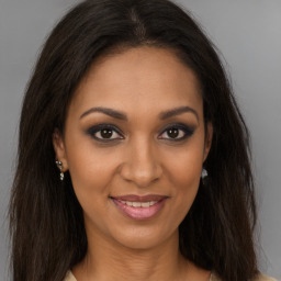 Joyful black young-adult female with long  brown hair and brown eyes