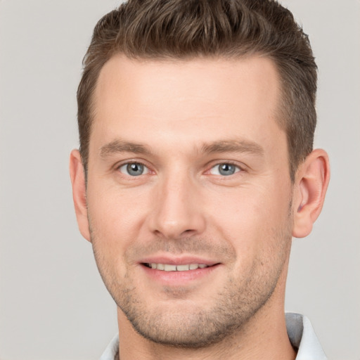 Joyful white young-adult male with short  brown hair and grey eyes