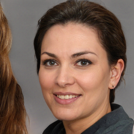 Joyful white adult female with medium  brown hair and brown eyes