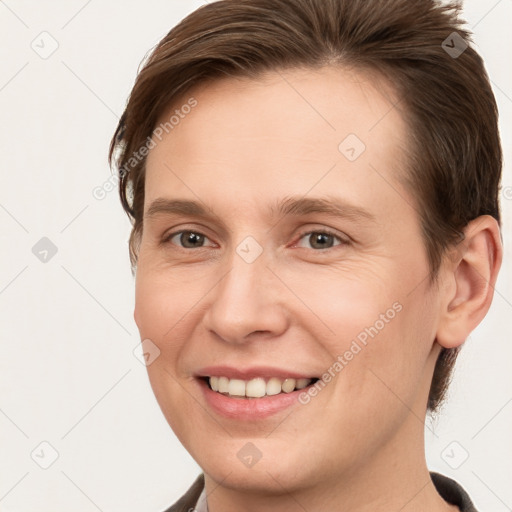 Joyful white young-adult female with short  brown hair and grey eyes