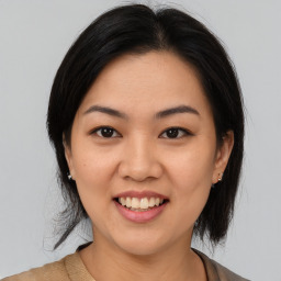 Joyful asian young-adult female with medium  black hair and brown eyes