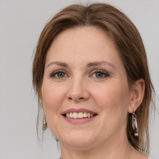 Joyful white adult female with medium  brown hair and green eyes