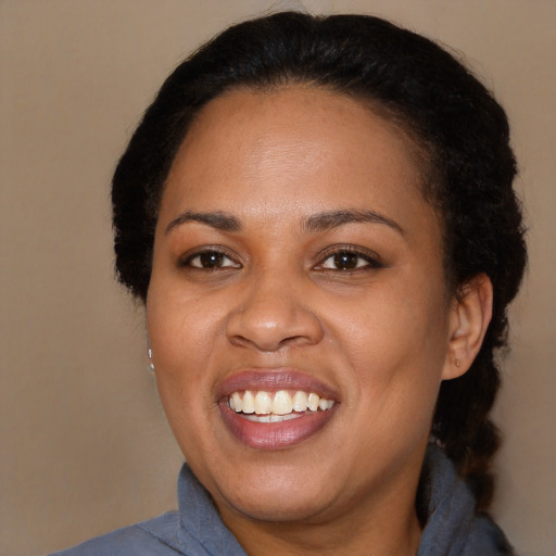 Joyful black young-adult female with long  brown hair and brown eyes