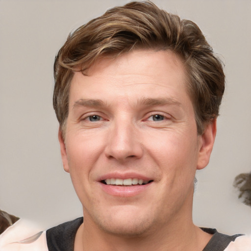 Joyful white adult male with short  brown hair and grey eyes