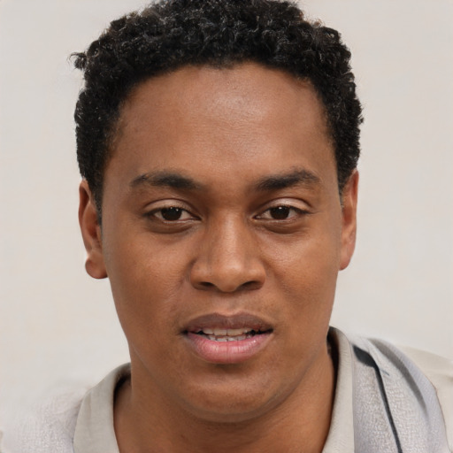 Joyful black young-adult male with short  brown hair and brown eyes