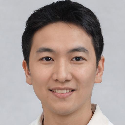 Joyful asian young-adult male with short  black hair and brown eyes