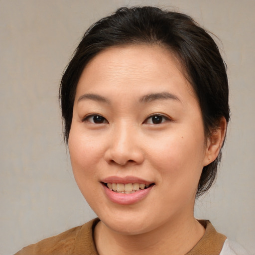 Joyful asian young-adult female with medium  brown hair and brown eyes