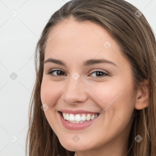 Joyful white young-adult female with long  brown hair and grey eyes