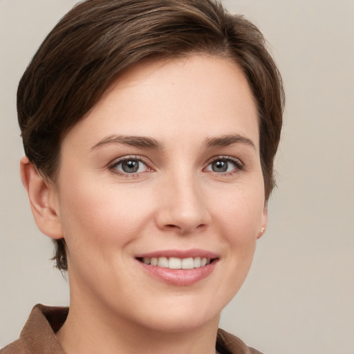 Joyful white young-adult female with short  brown hair and grey eyes