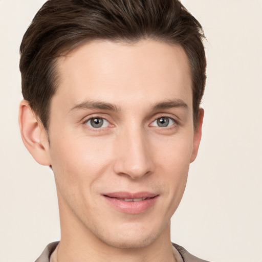 Joyful white young-adult male with short  brown hair and grey eyes