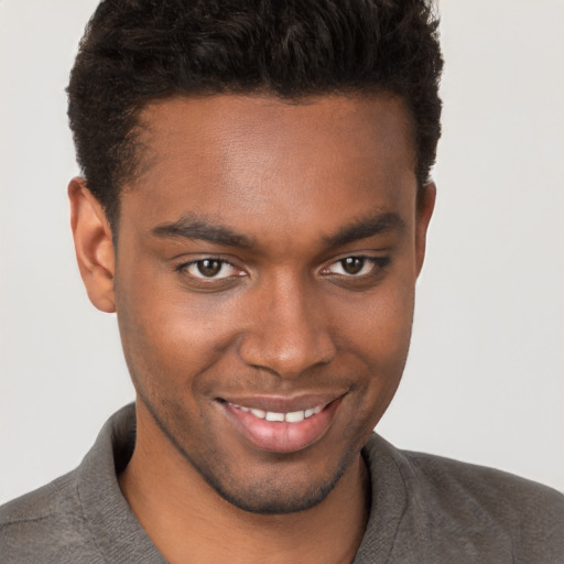 Joyful black young-adult male with short  brown hair and brown eyes