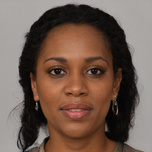 Joyful black young-adult female with long  brown hair and brown eyes