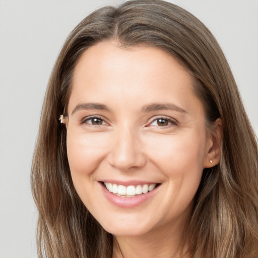 Joyful white young-adult female with long  brown hair and brown eyes