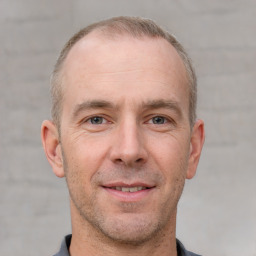 Joyful white adult male with short  brown hair and grey eyes