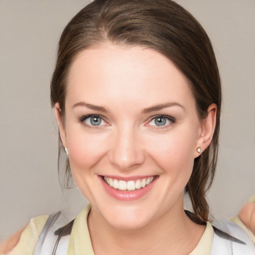 Joyful white young-adult female with medium  brown hair and blue eyes