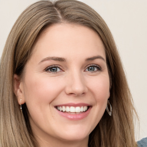 Joyful white young-adult female with long  brown hair and green eyes