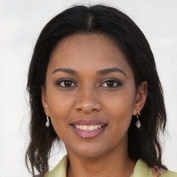 Joyful black young-adult female with long  brown hair and brown eyes