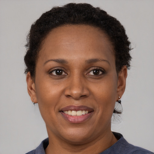 Joyful black adult female with short  brown hair and brown eyes