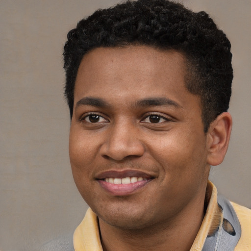 Joyful black young-adult male with short  black hair and brown eyes