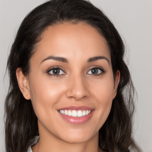 Joyful white young-adult female with long  brown hair and brown eyes