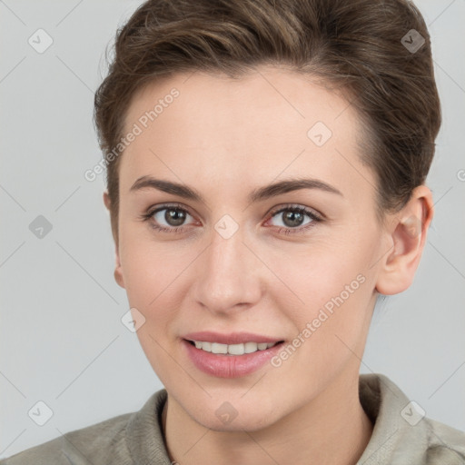 Joyful white young-adult female with short  brown hair and grey eyes