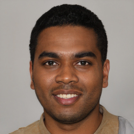Joyful black young-adult male with short  black hair and brown eyes