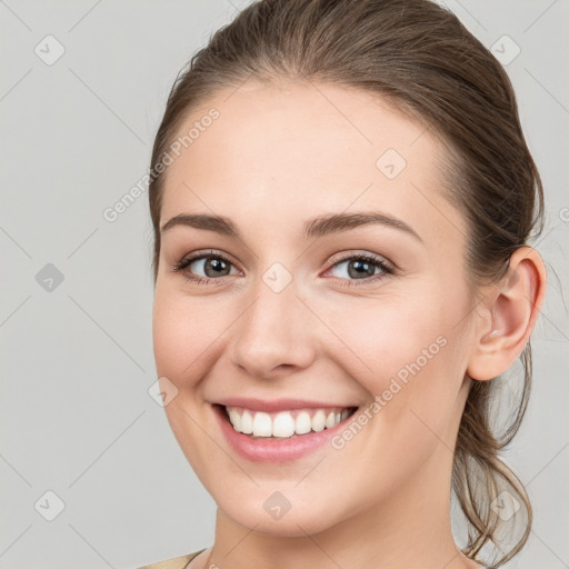 Joyful white young-adult female with medium  brown hair and grey eyes