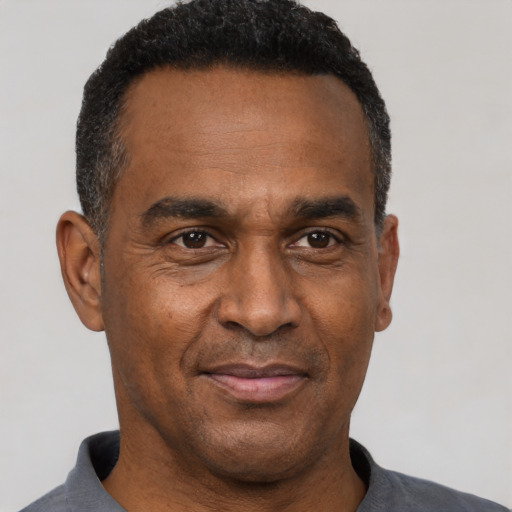 Joyful black adult male with short  black hair and brown eyes
