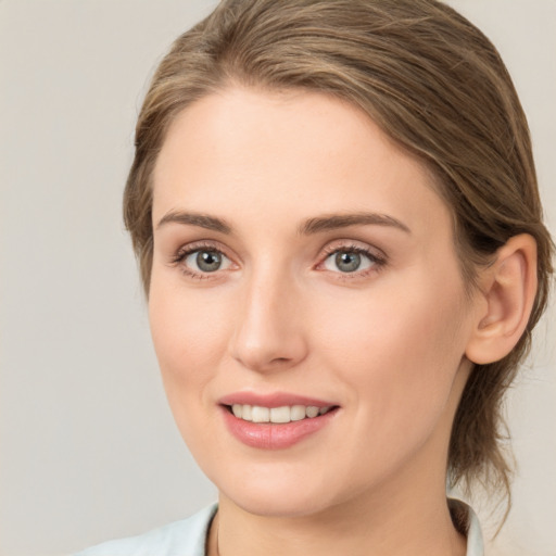 Joyful white young-adult female with medium  brown hair and grey eyes