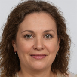 Joyful white adult female with medium  brown hair and green eyes