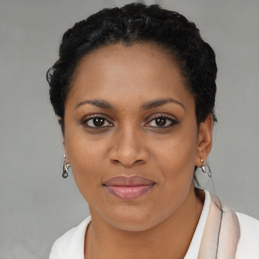 Joyful black young-adult female with short  brown hair and brown eyes