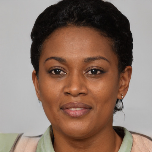 Joyful black young-adult female with short  black hair and brown eyes