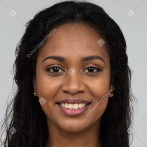 Joyful black young-adult female with long  brown hair and brown eyes