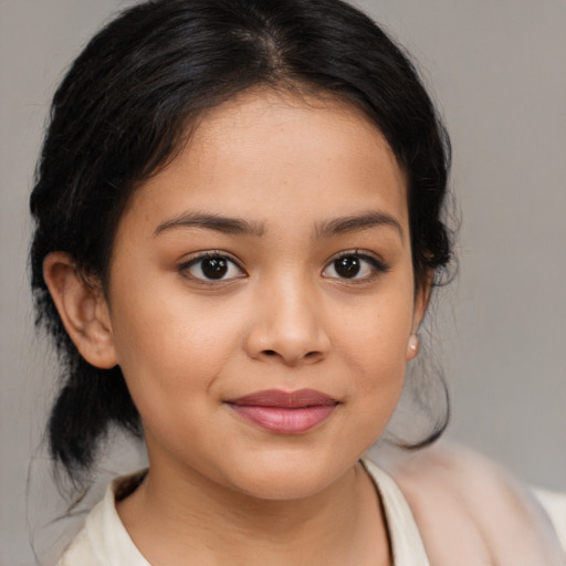 Joyful latino child female with medium  brown hair and brown eyes