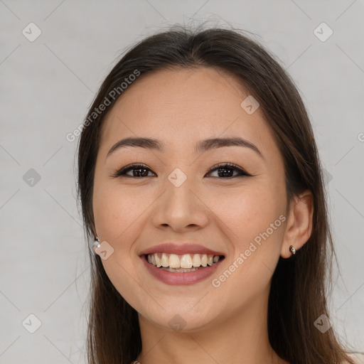 Joyful latino young-adult female with long  brown hair and brown eyes