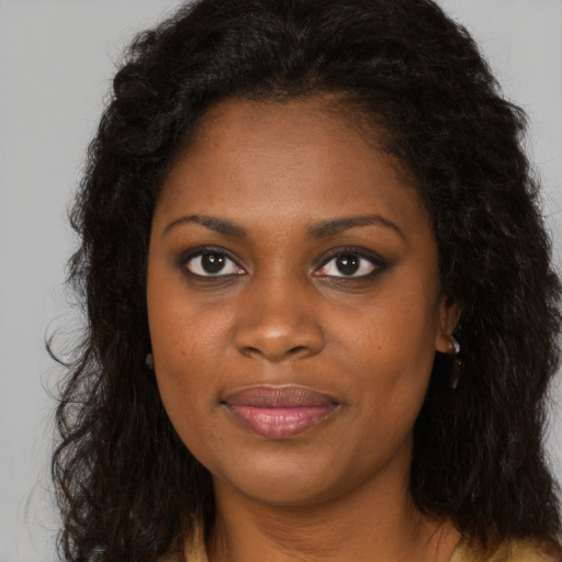 Joyful black young-adult female with long  brown hair and brown eyes