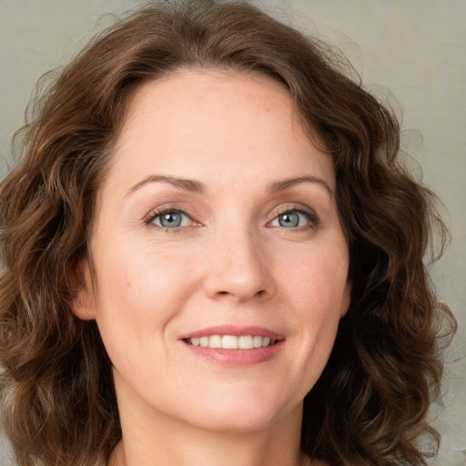 Joyful white adult female with medium  brown hair and green eyes