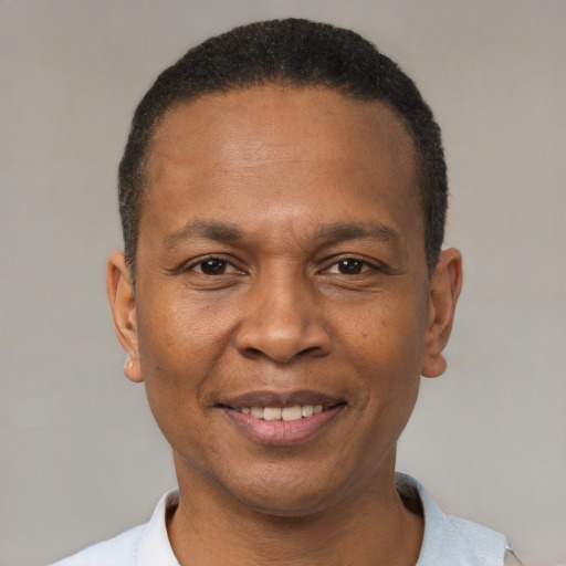Joyful black adult male with short  black hair and brown eyes
