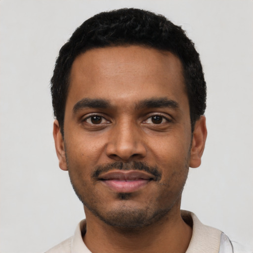 Joyful black young-adult male with short  black hair and brown eyes