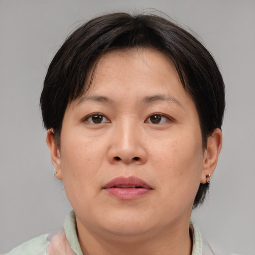 Neutral asian adult female with medium  brown hair and brown eyes
