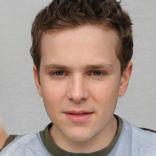 Joyful white young-adult male with short  brown hair and blue eyes