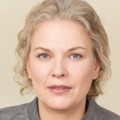 Joyful white adult female with medium  brown hair and blue eyes