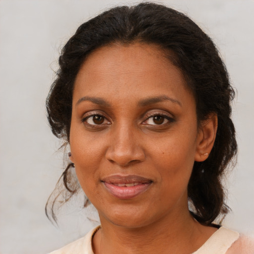 Joyful black adult female with medium  brown hair and brown eyes