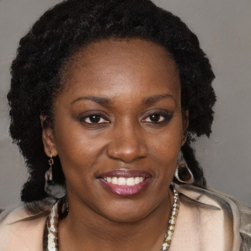 Joyful black young-adult female with long  brown hair and brown eyes
