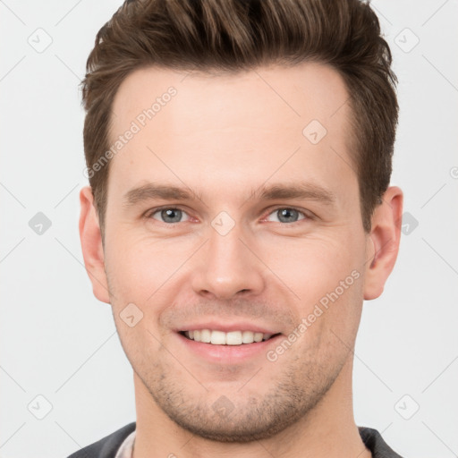 Joyful white young-adult male with short  brown hair and grey eyes