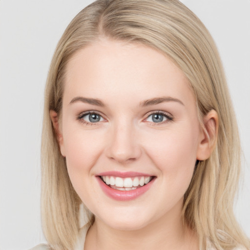 Joyful white young-adult female with long  brown hair and blue eyes