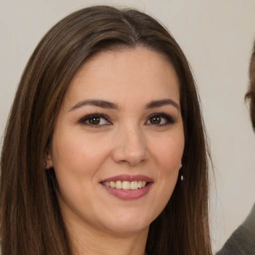 Joyful white young-adult female with long  brown hair and brown eyes