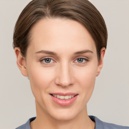 Joyful white young-adult female with short  brown hair and grey eyes