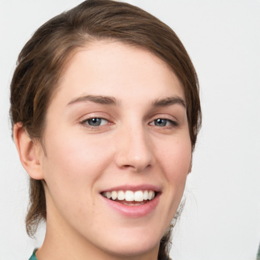 Joyful white young-adult female with medium  brown hair and green eyes